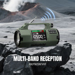 Load image into Gallery viewer, Green Raddy SH-907 Emergency Radio on a rocky surface with a mountain and volcano in the background, featuring text about multi-band reception.
